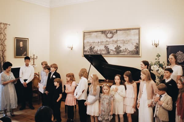 Unisono Music Academy students lined up by the grand piano at the end of the Annual Concert 2026 in the Szuster Palace in Warsaw