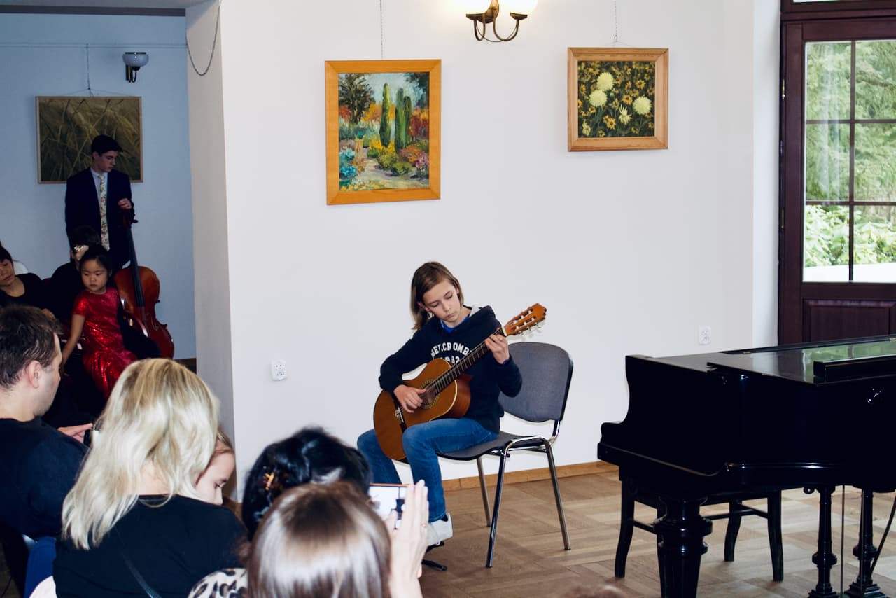 Unisono Music Academy student playing classical guitar at a concert in the Szuster Palace in Warsaw