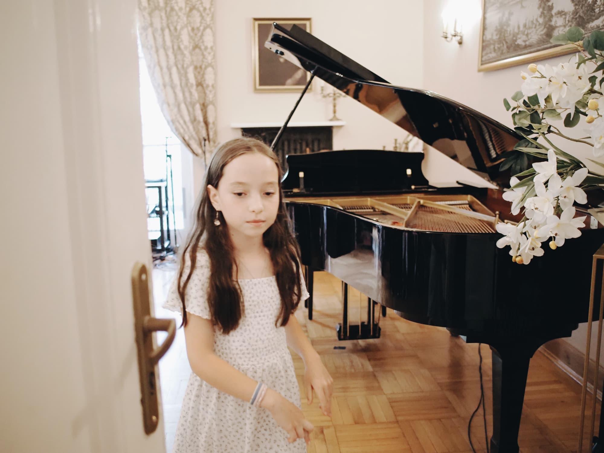 Young soloist after her performance A girl standing beside the grand piano after her performance at the Annual Concert of 2026